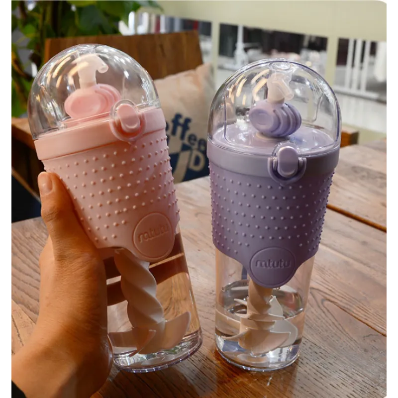 A hand holding a colorful water bottle with a knitted sleeve.